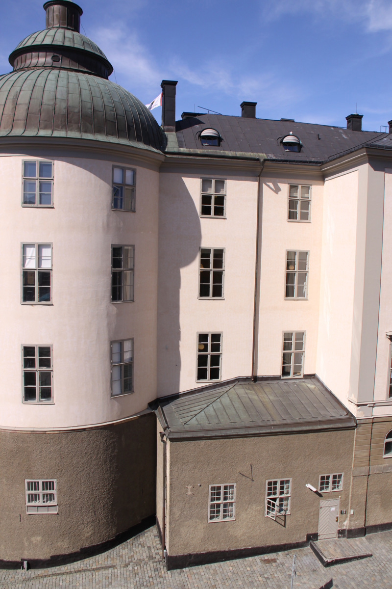 Wrangelska palatsets runda torn med kupol. Fasaden är grå på gatuplan, men vitputsad på de högre våningarna.