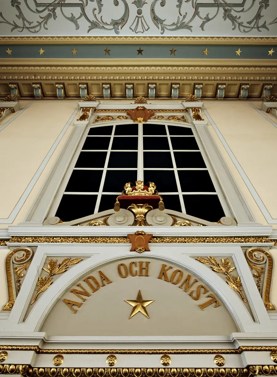 Interiörbild av dekorationer. I taket syns guldstjärnor. I ett portvalv står texten "anda och konst" i guldskrift.