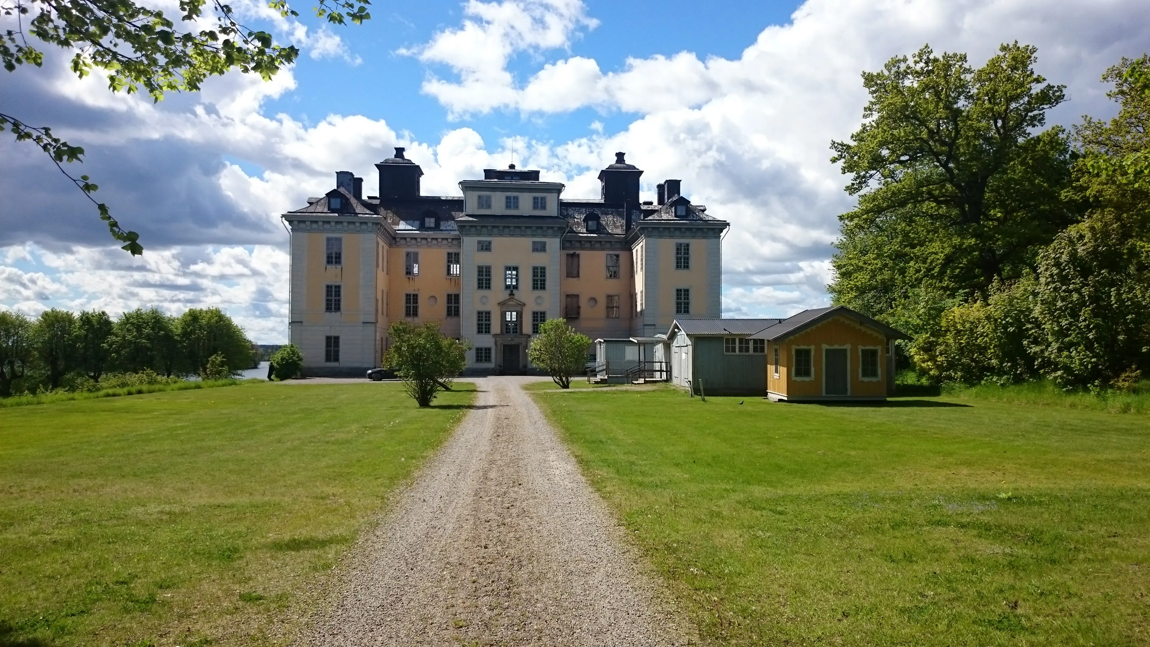 Mälsåkers slott och slottspark. Stora gräsytor runt slottet kantas av lummiga träd.