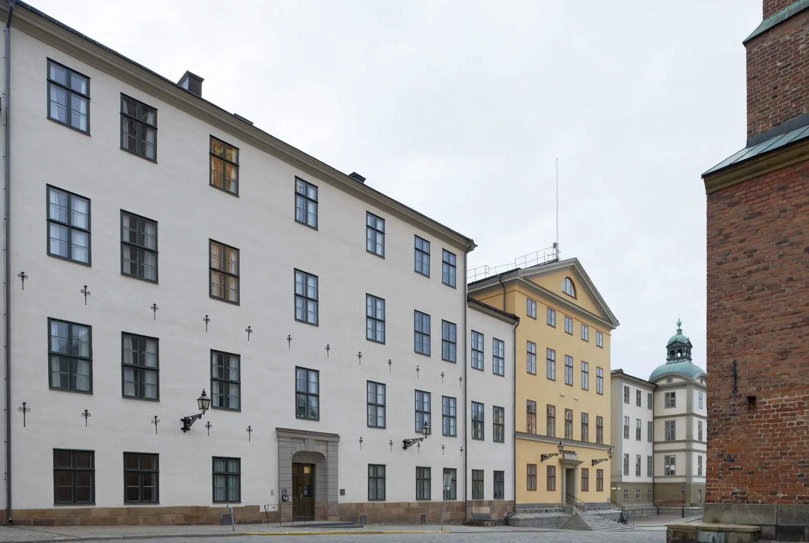 Sparreska palatsets vita fasad med ankarslut. Till höger i bild skymtar Riddarholmskyrkan.