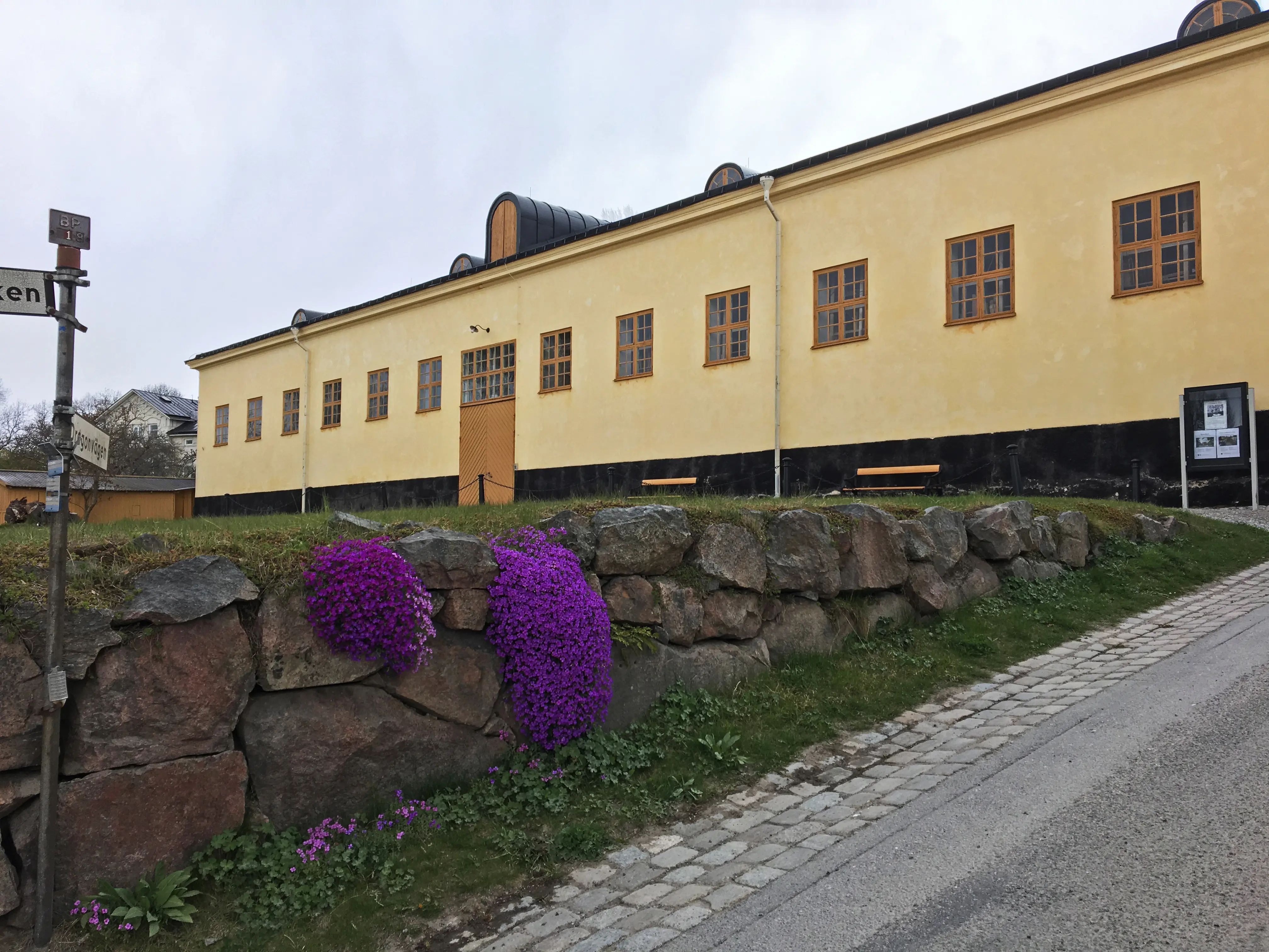 Dragonstallet på Malmen vid Drottningholm. Låg, gul stall-byggnad