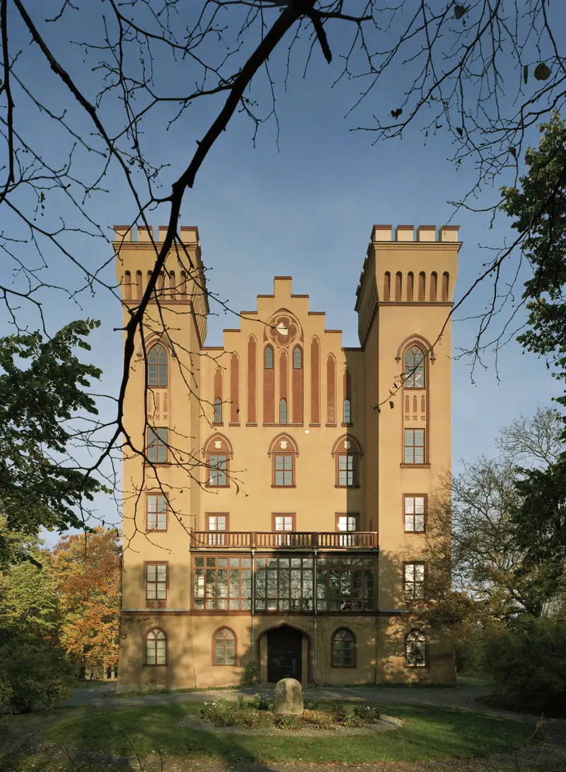 Bogesunds slott sett från baksidan omgivet av lövträd i höstfärger.