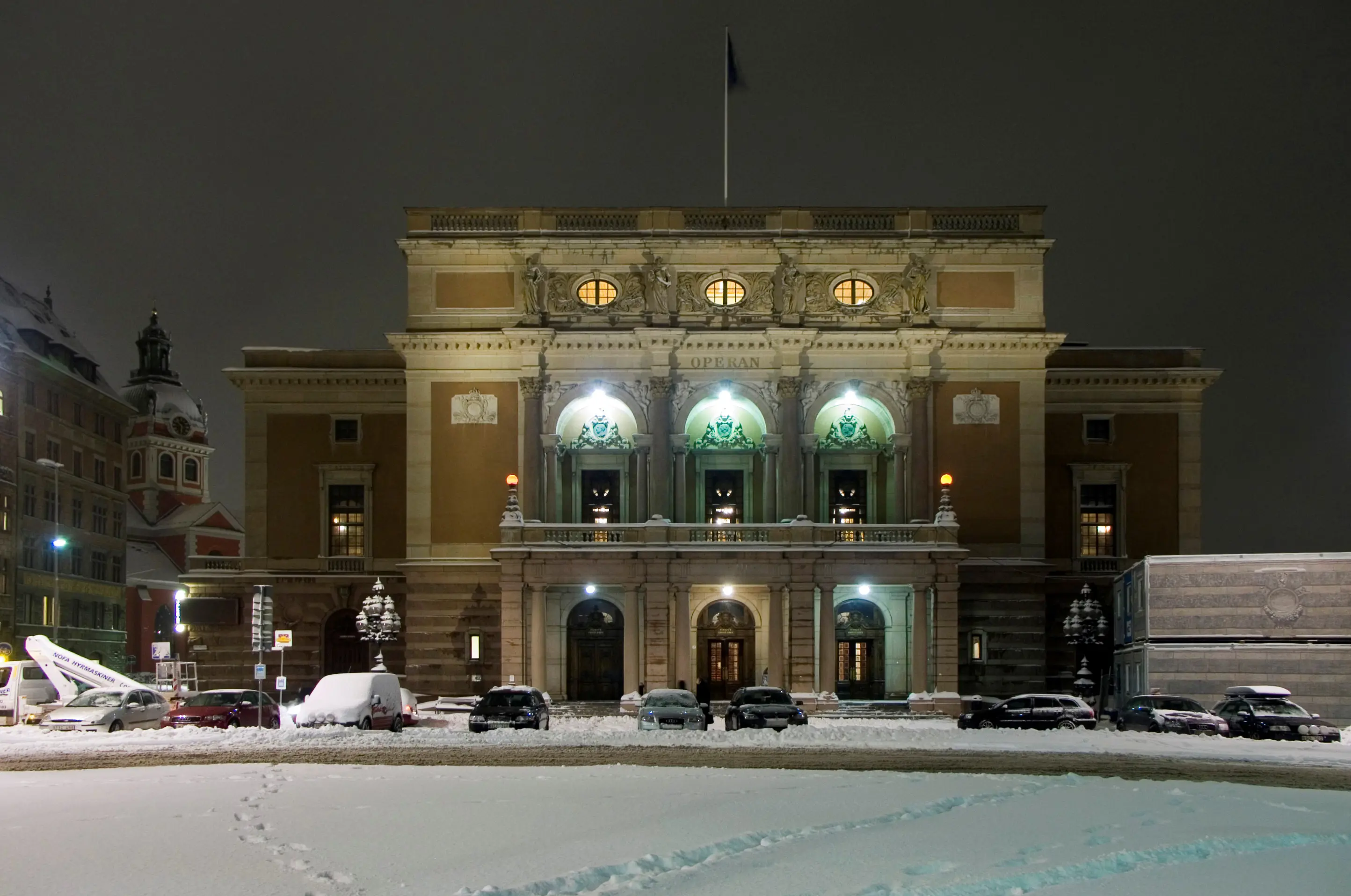 Operans entréfasad med kvällsbelysning. Vinter och snö.