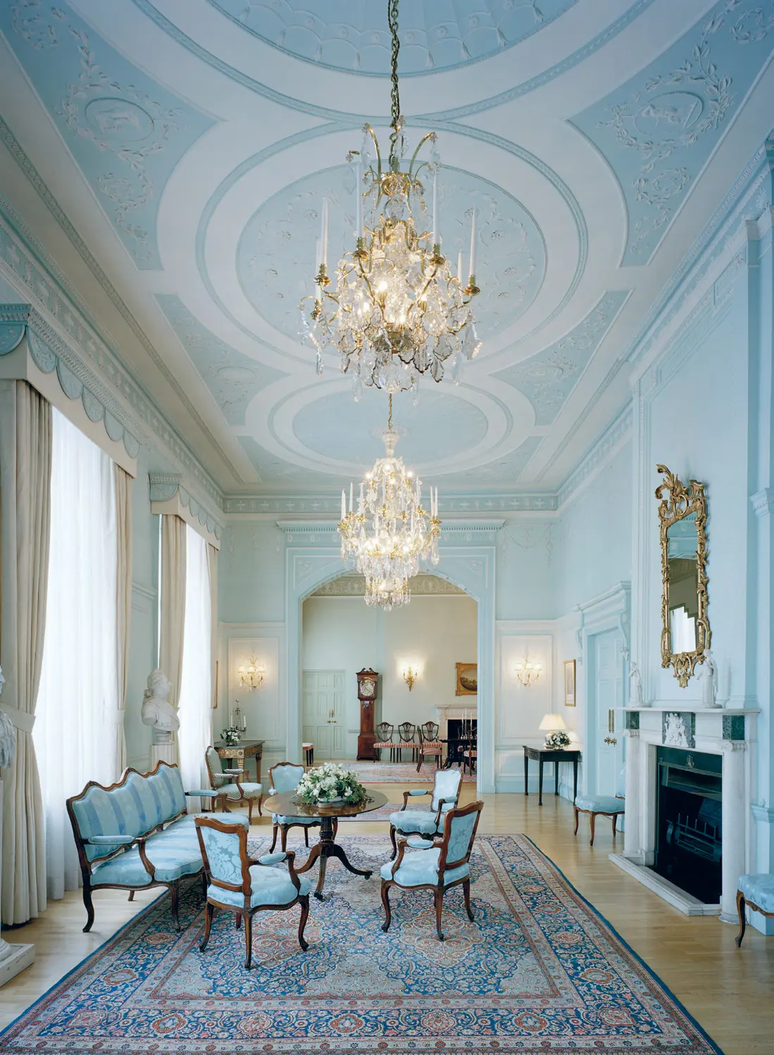 Ambassadresidenset i London. Salong med kristallkronor och öppen spis. Inredningen är i rokoko-stil och går i ljusblått.