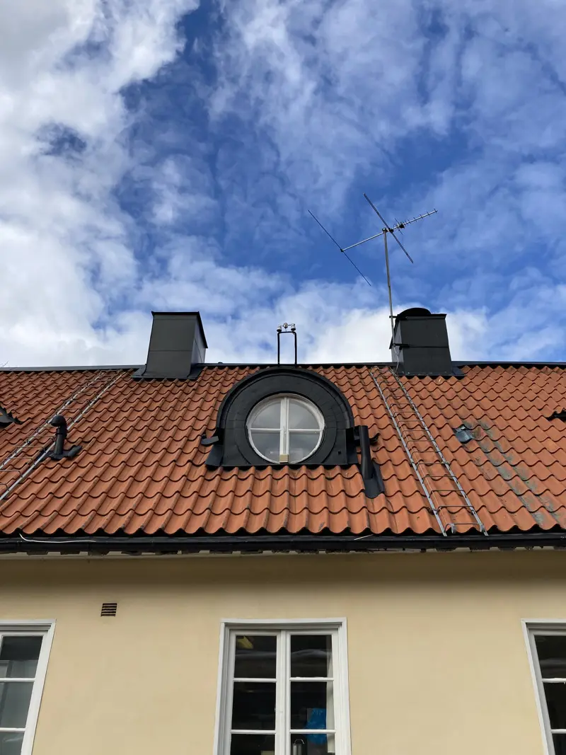 Brostugans fasad. Gul puts och röda takpannor.