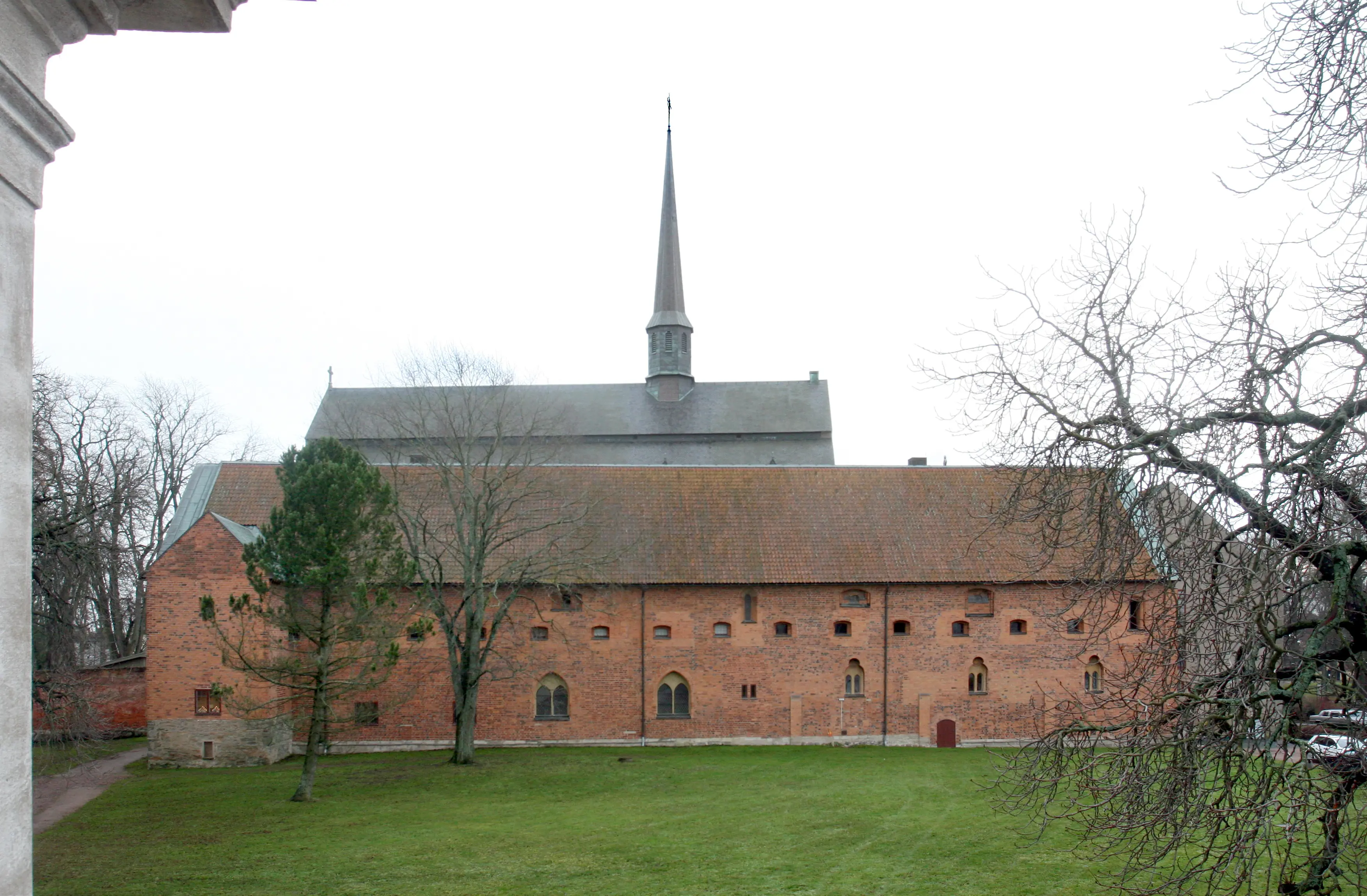 Nunneklostret, Vadstena. Norra längan. En stor, medeltida tegelbyggnad med brant tegeltak. Bakom syns klosterkyrkan.