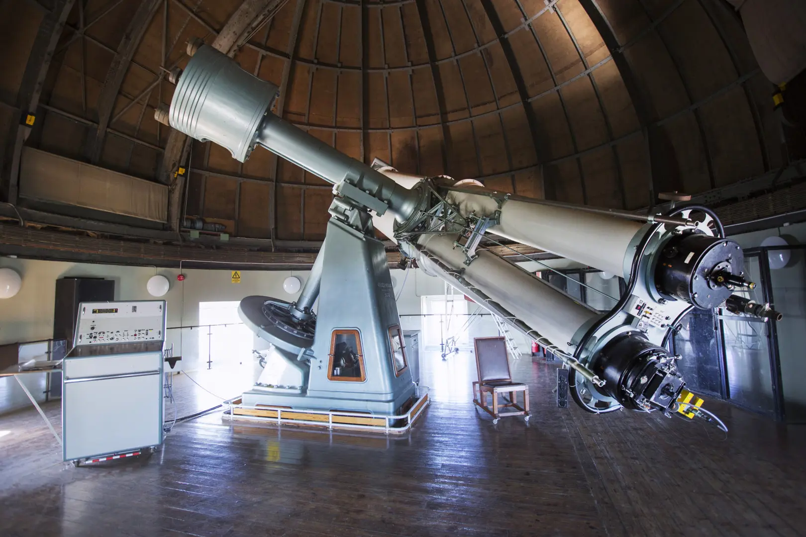Stort teleskop inne i en kupolformad byggnad.