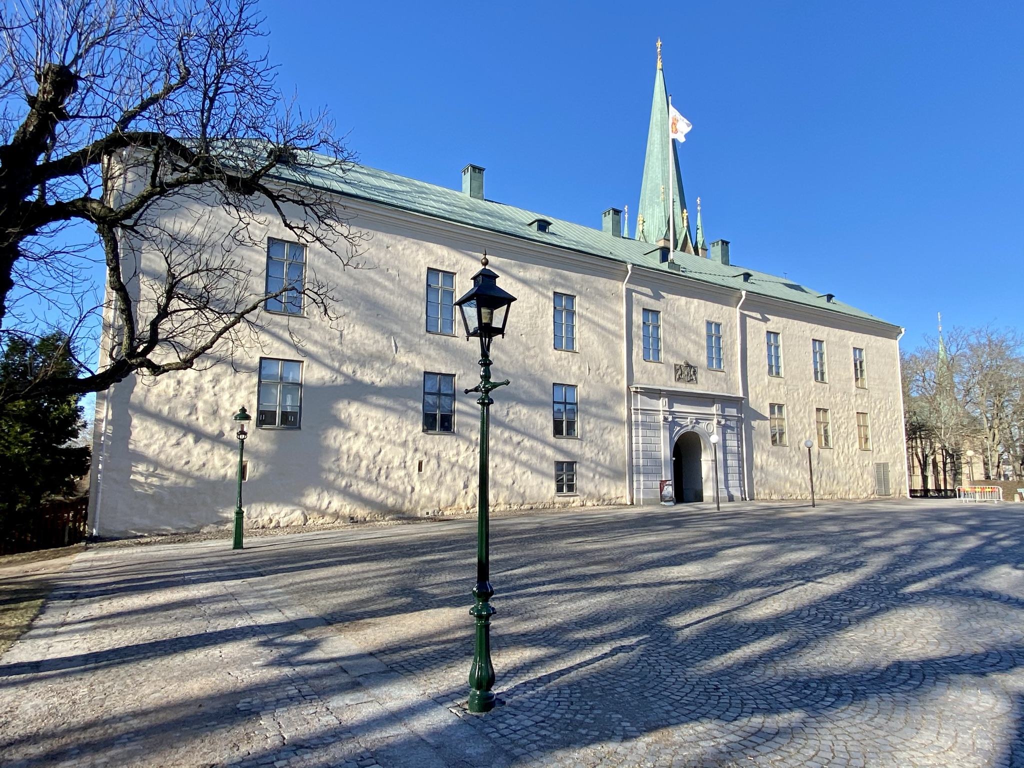 Linköpings slott, fasaden mot torget. En vitputsad tvåvåningsbyggnad med koppartak och en pampig, klassicistisk portal.