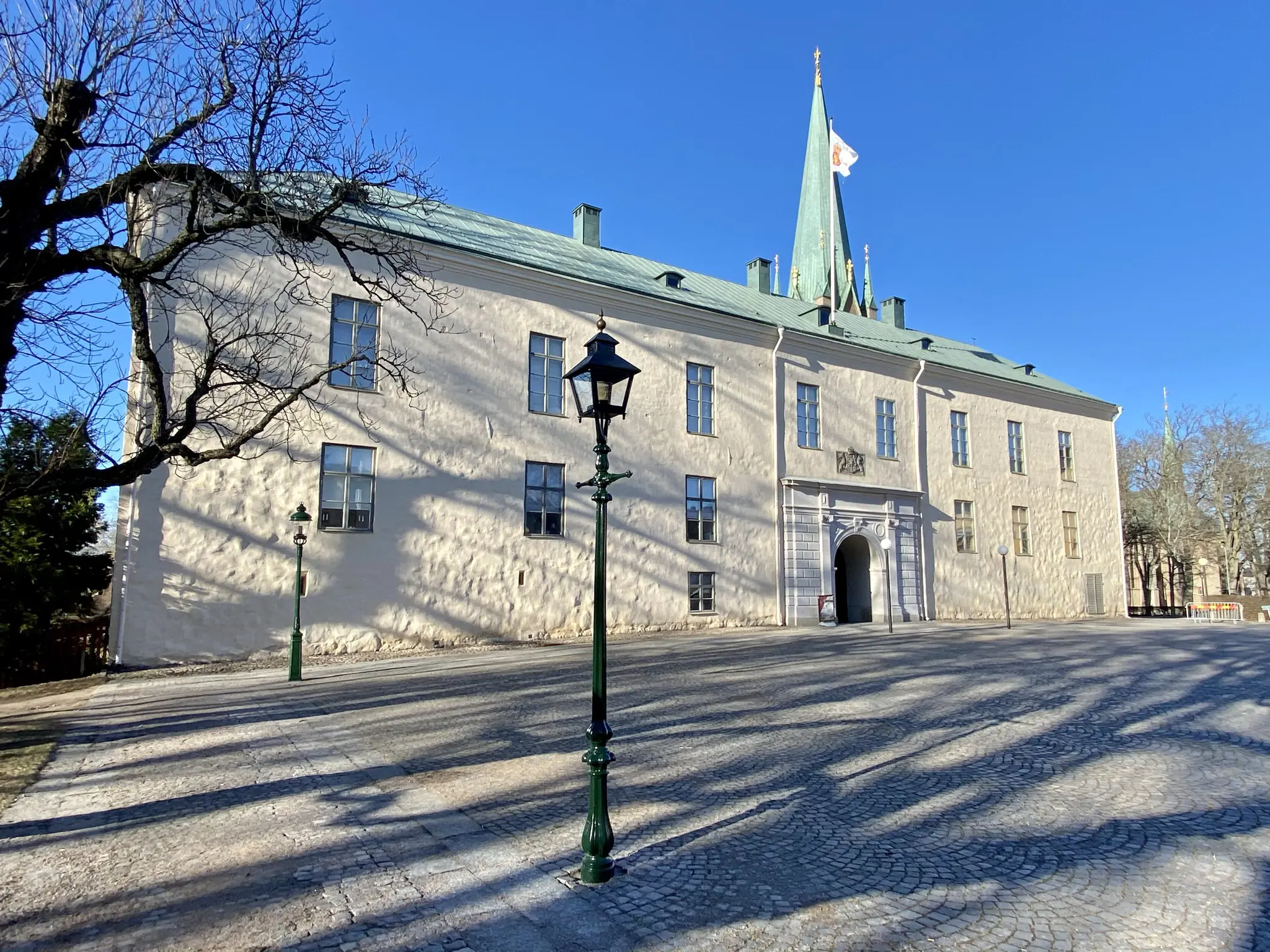 Linköpings slott, fasaden mot torget. En vitputsad tvåvåningsbyggnad med koppartak och en pampig, klassicistisk portal.