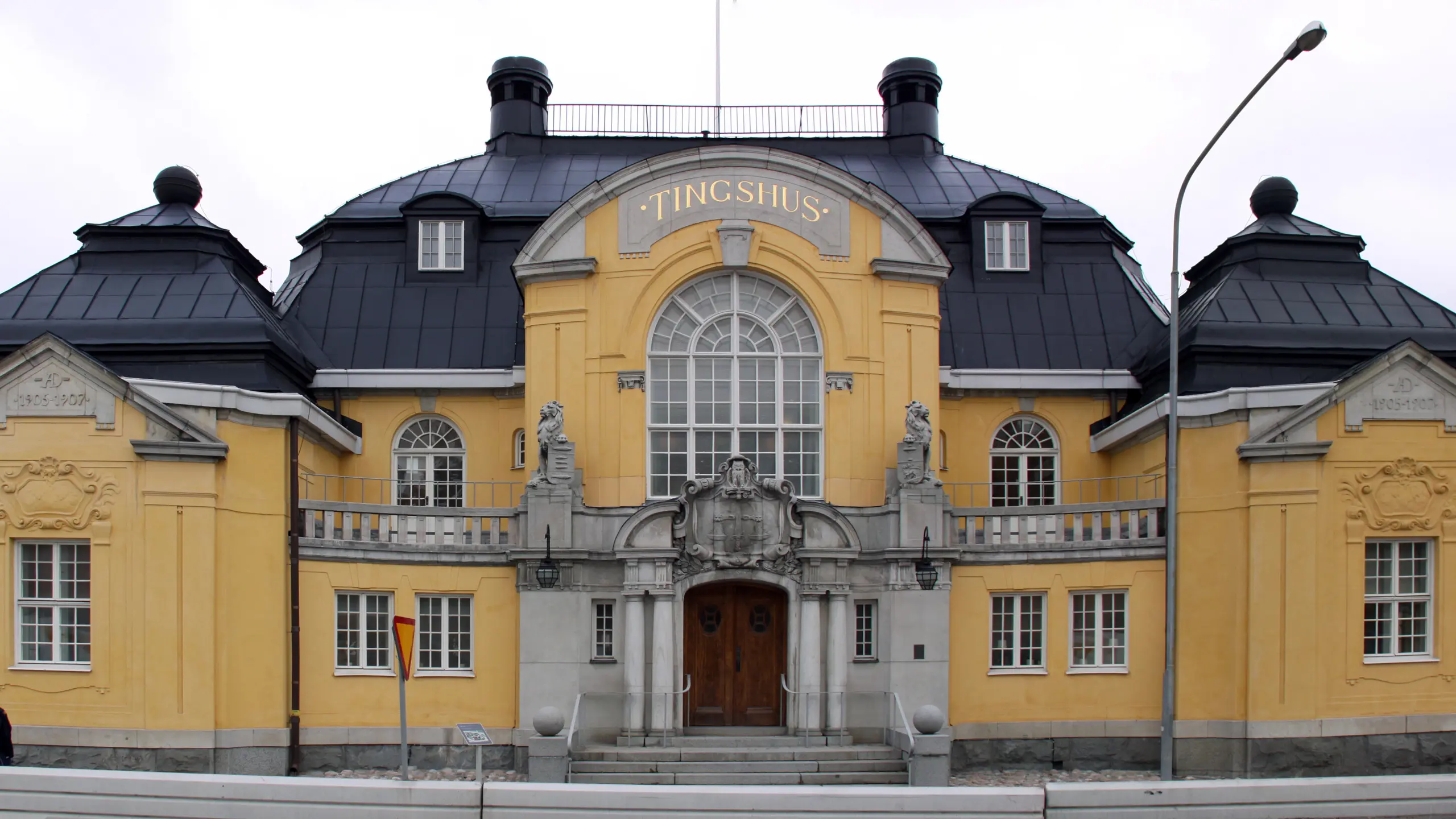 Haga tingshus. Gulputsad byggnad i jugendbarock. Entréfasaden pryds av en rundad mittgavel med stort fönster och pampig stenportal.