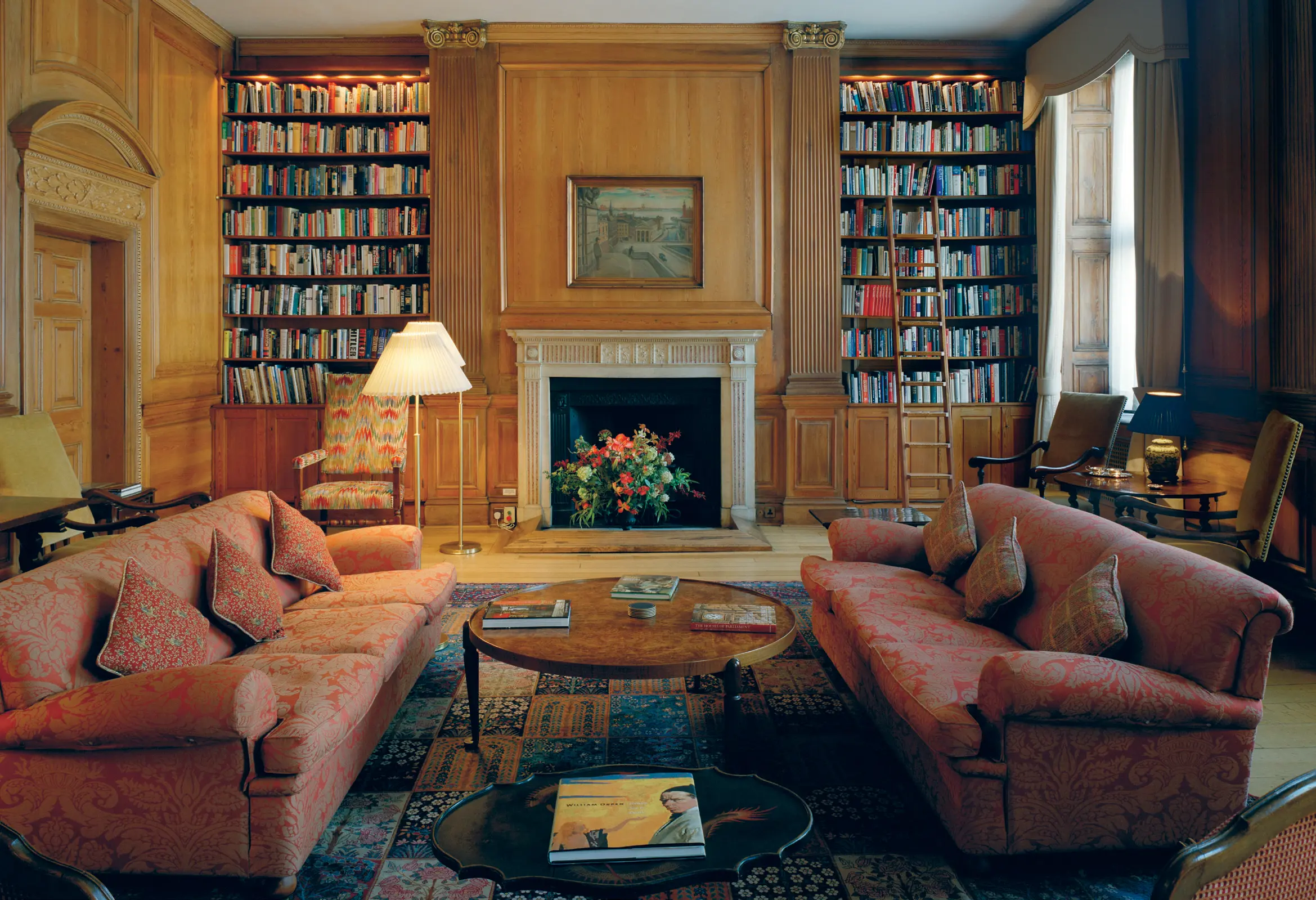 Interiör, amdassad-residenset i London. Bibliotek med eldstad, stora soffor och trä-klädda väggar med klassicitisk utsmyckning.