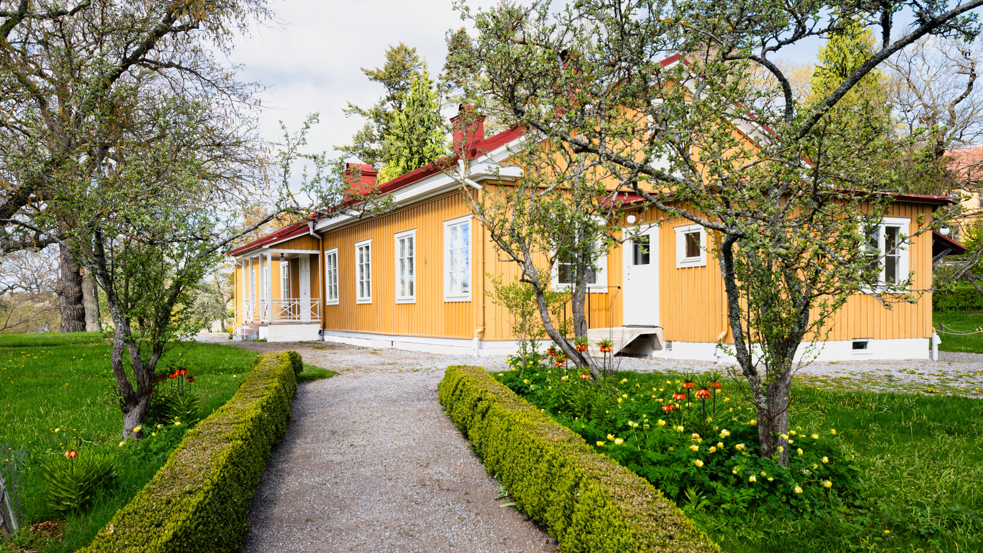 Bergianska trädgården, Bleket. Gult envåningshus med rött tak. En grusgång leder fram till huset mellan gräsmattor.