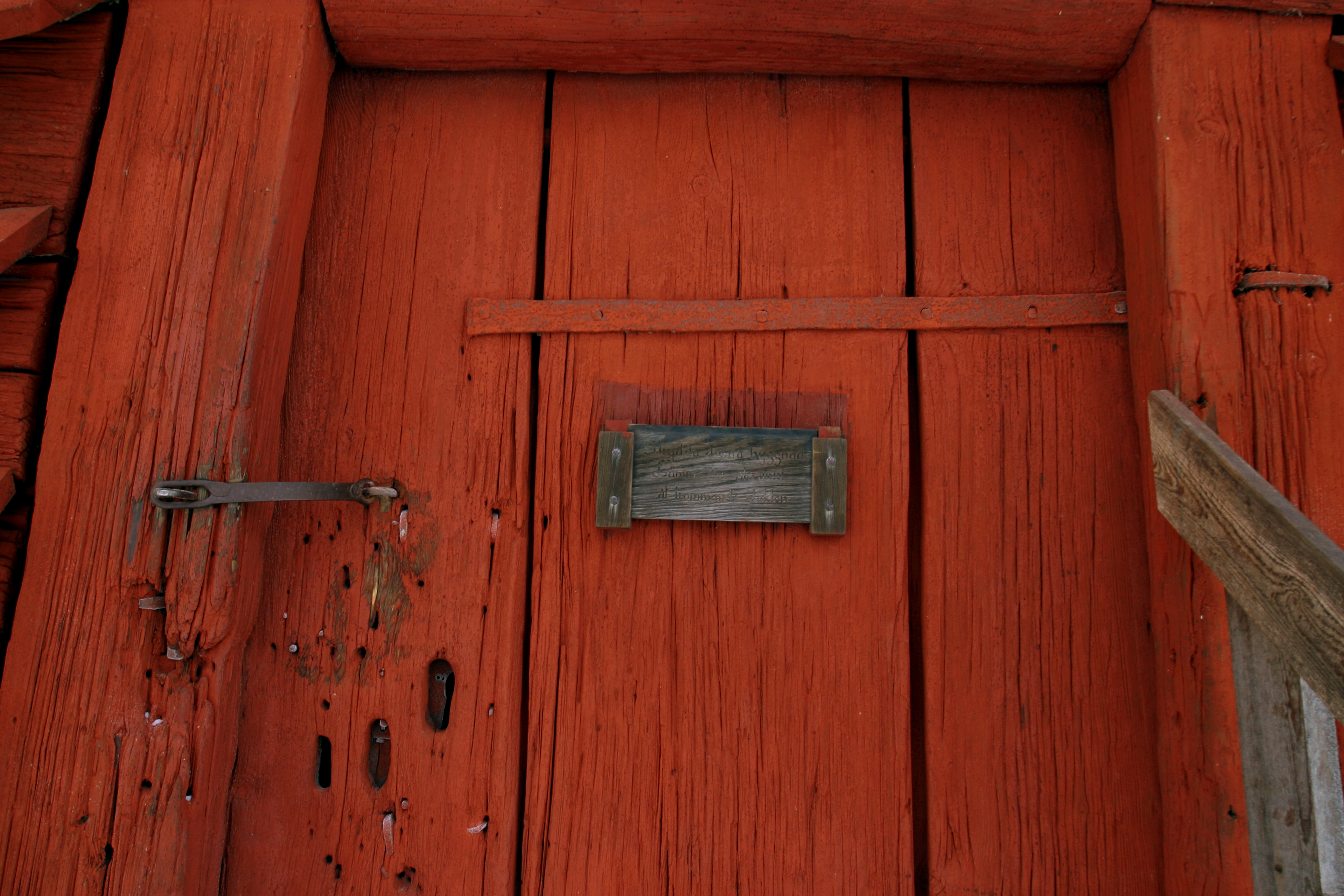 Rankhyttan, fasad. Den faluröda dörren är stängd med en enkel hasp.