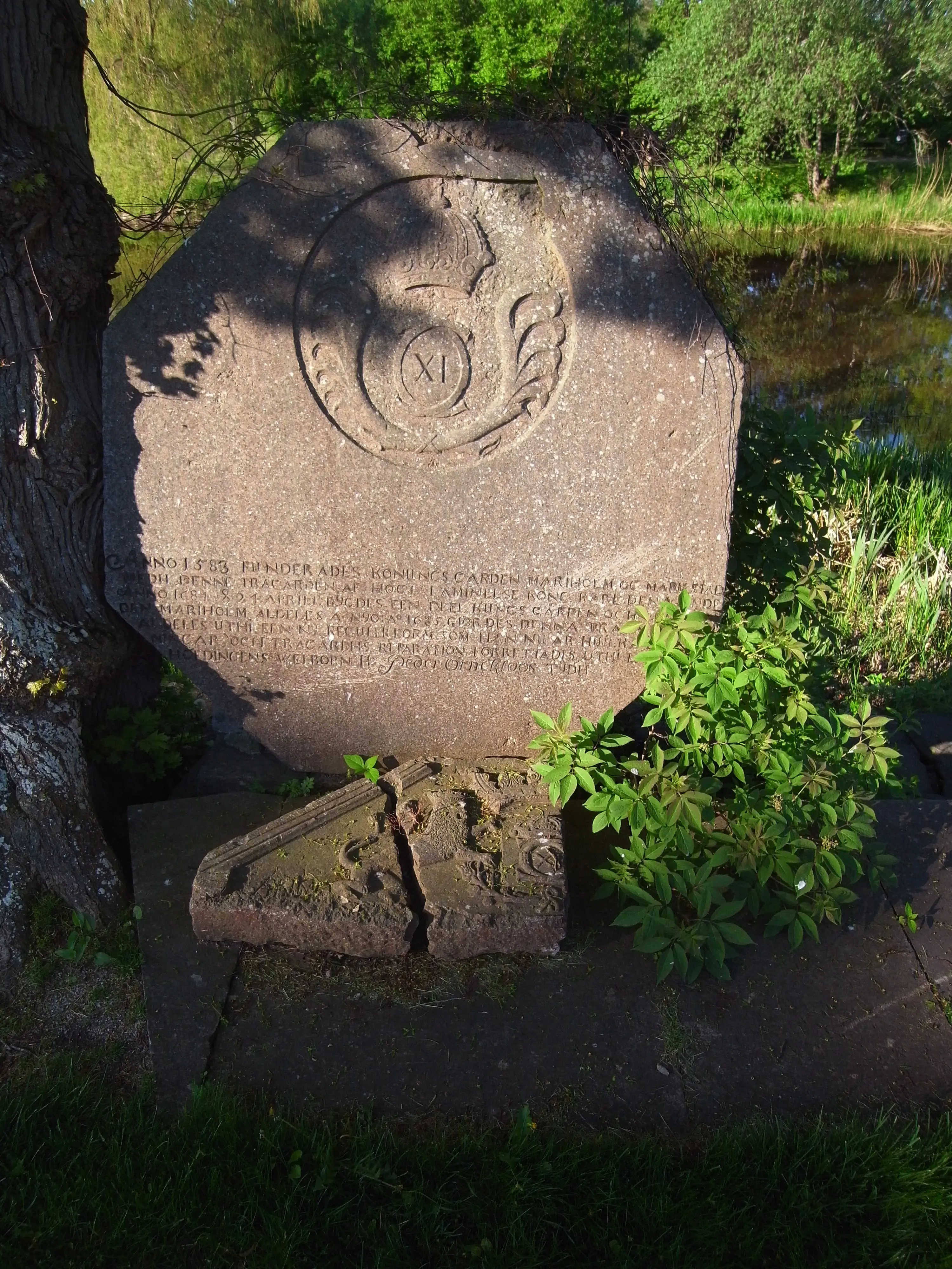 Örneklous minnes-sten vid residenset Marieholm. Åttakantig stentavla med Karl den elftes vapen.